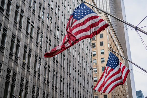 17 - Edwards Law An image showing American flags blowing in the wind through a downtown city setting.